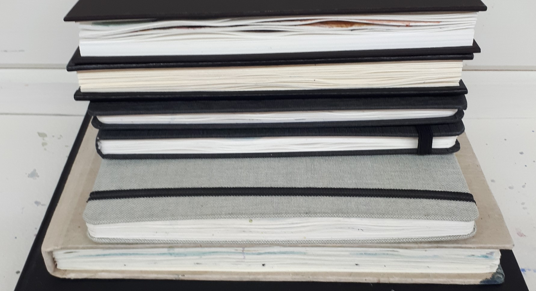 A pile of artist sketchbooks