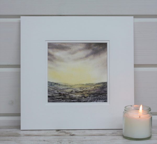Golden Dawn a mounted painting of a sunrise with a candle in front.