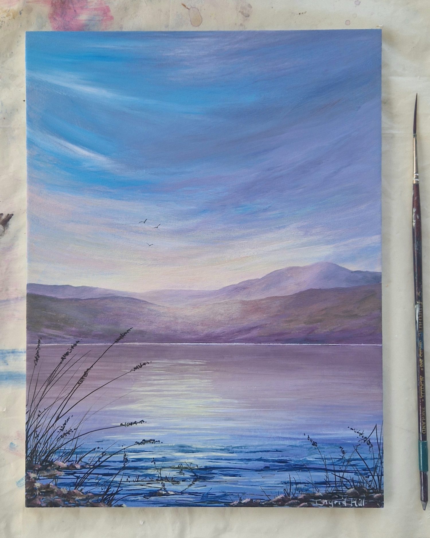 Soft Haze is an atmospheric acrylic painting. The sky is reflecting in the water with softly coloured hills in the distance.