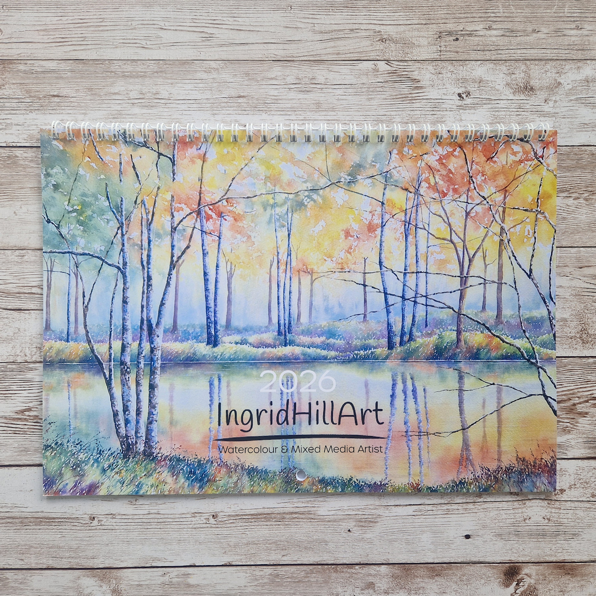 Front cover of a 2026 calendar showing an autumn woodland painting