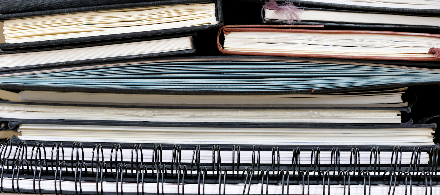 Sketchbooks stacked on top of each other.