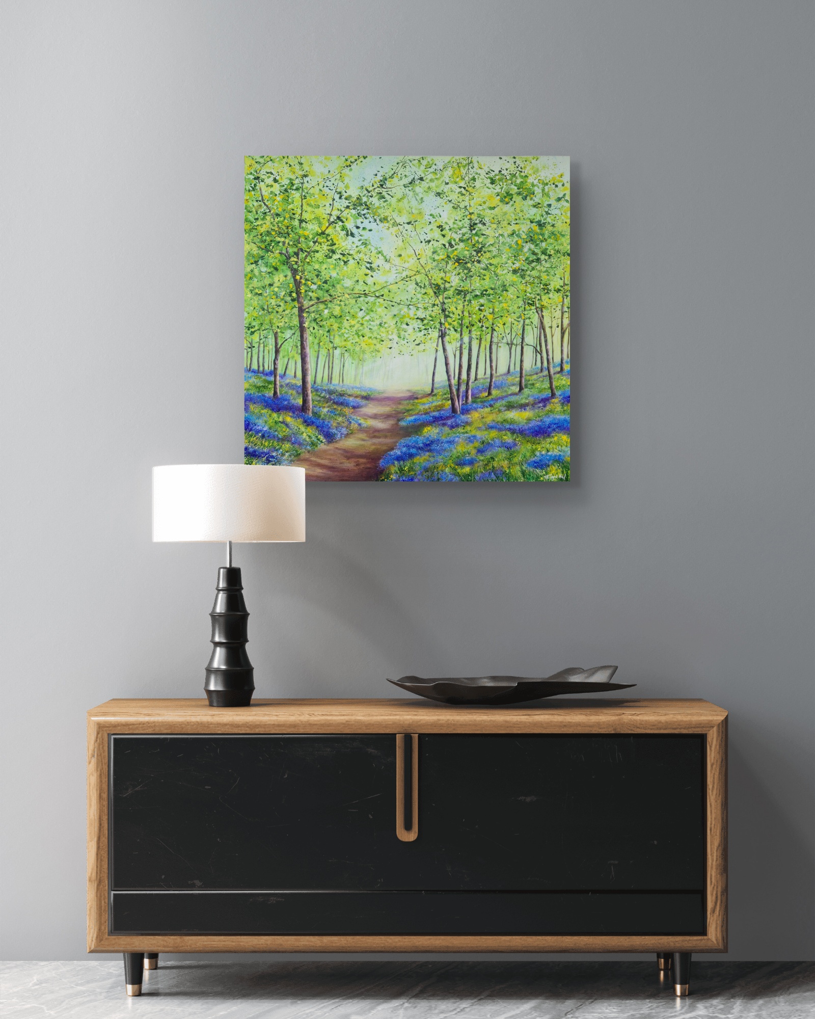 An example of an interior setting with a painting of a bluebell wood on a wall over a desk.
